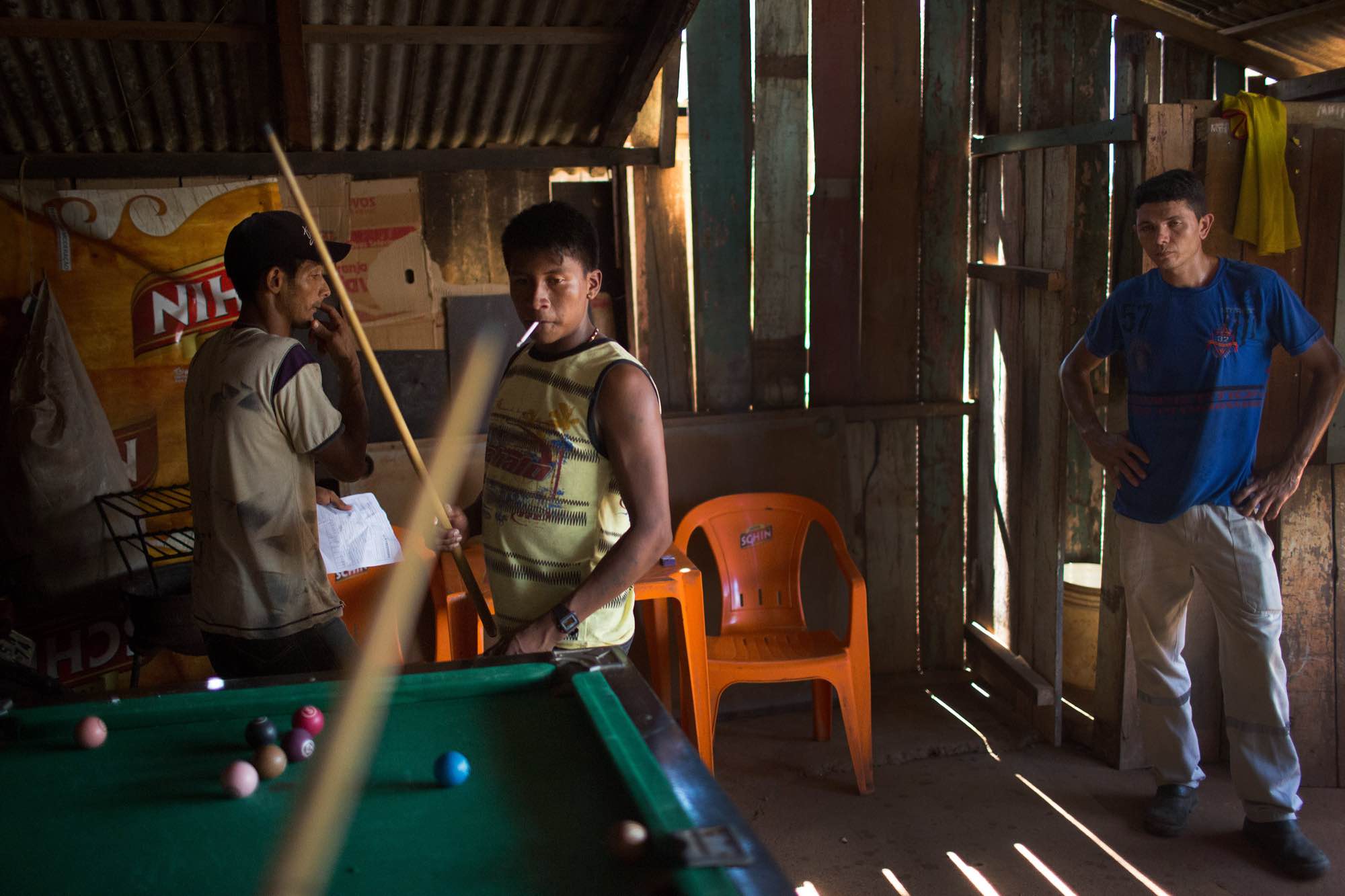 Bekre, a young Xikrin man, plays pool with friends in an Altamira bar.
