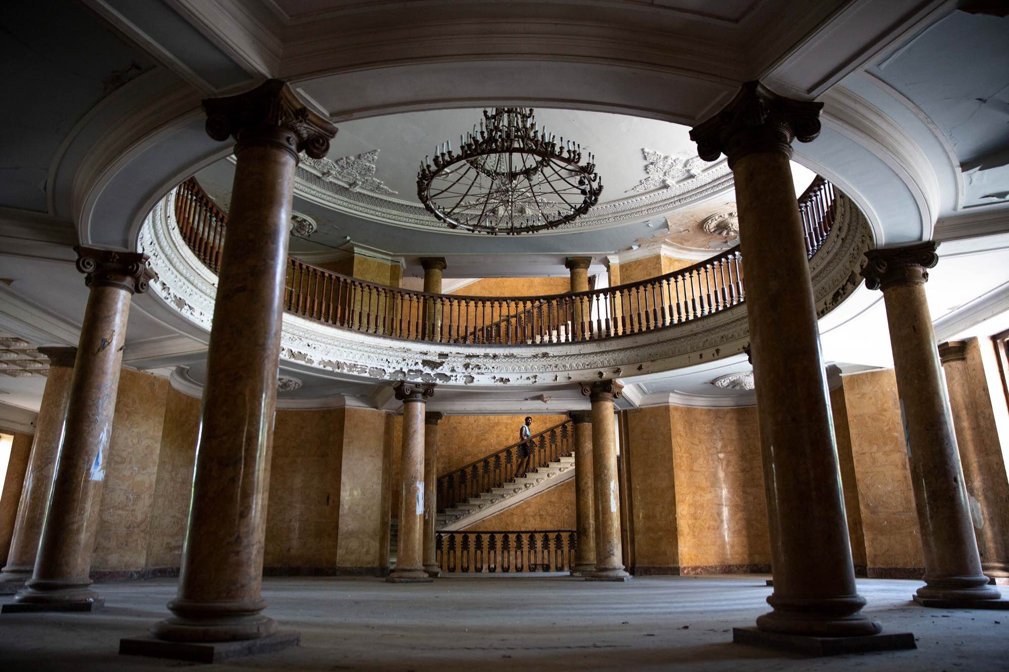 After showering, a man walks up the stairs in the lobby at Sanatorium Metallurgi in Tskatulbo, Georgia on June 16, 2019.
