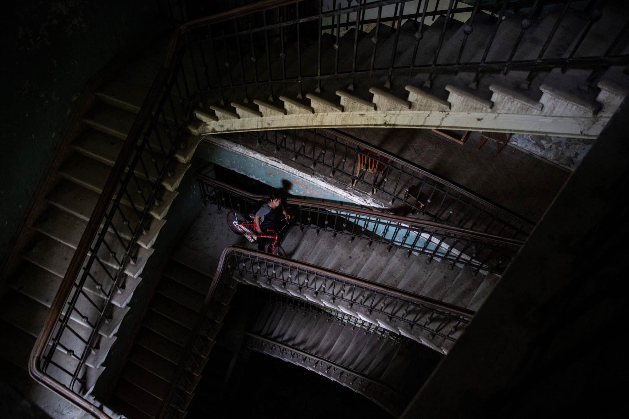 Jana Managadze, 42, carries a bicycle up stairs at Sanatorium Medea in Tskatulbo, Georgia on June 15, 2019.