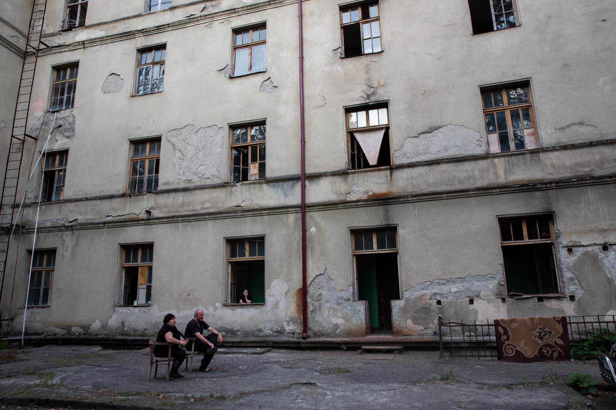 Murtazi Vekua, 52, and Khatuna Meshveliani, 45, sit outside and talk with their neighbor, Lamara Kirtadze at Sanatorium Rkinigza in Tskatulbo, Georgia on…