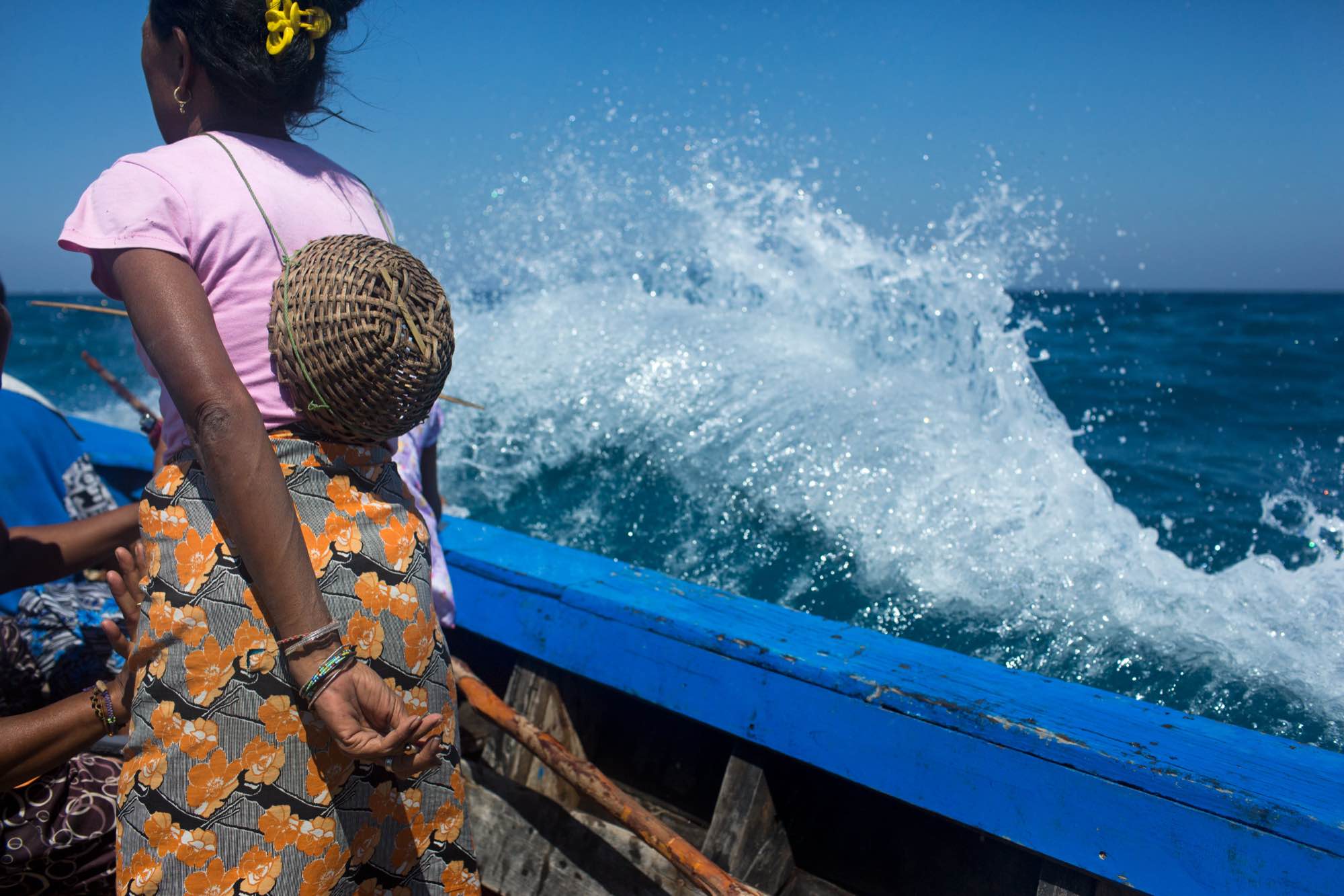 Moken women ride through rough seas on a trip to forage for food on a nearby beach.