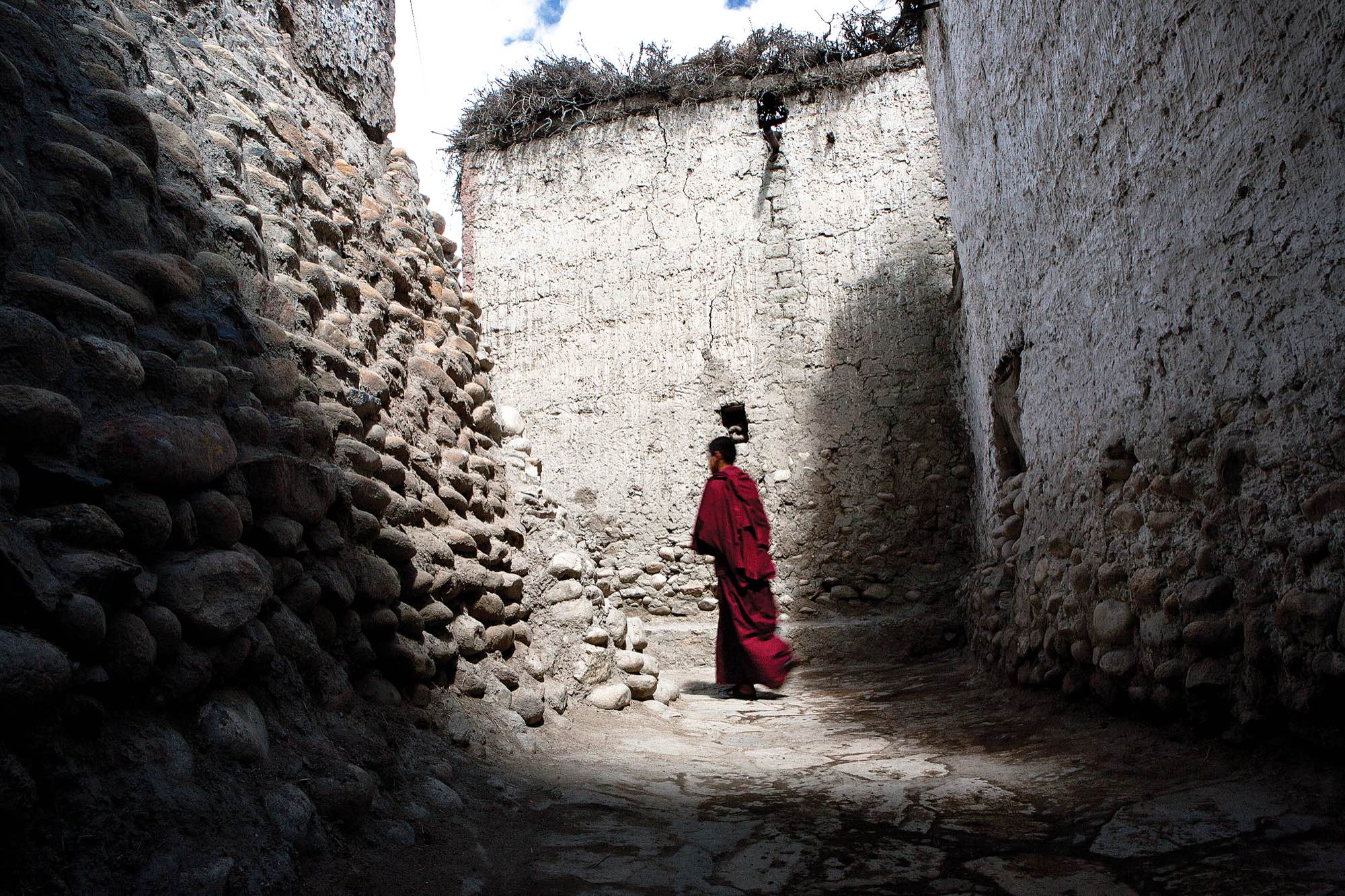 A monk walks through the alleyways of Lo Manthang.