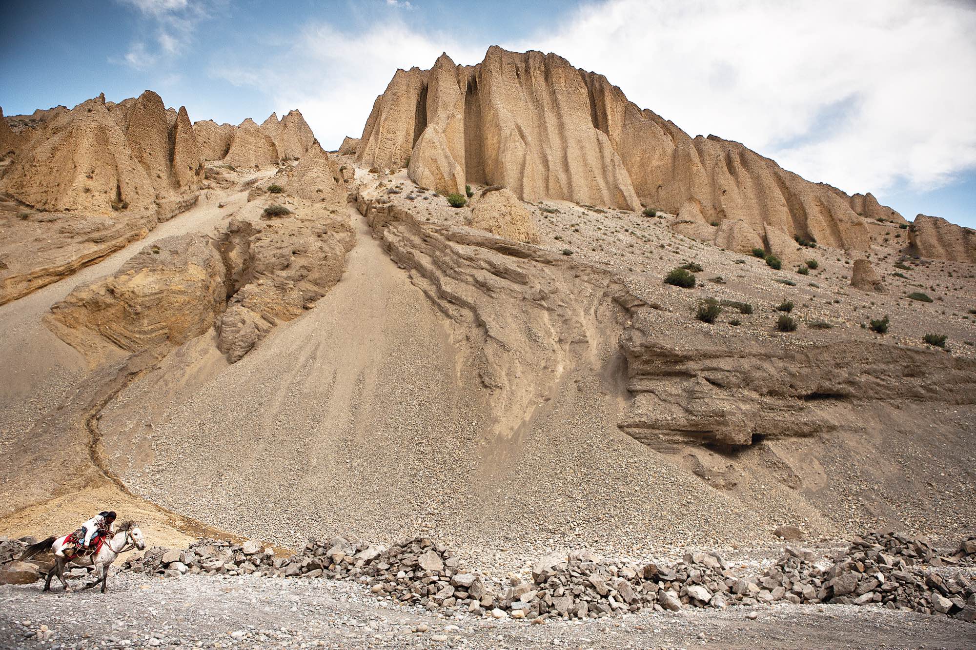 A young man rides his horse down the Kali Gandaki River valley.