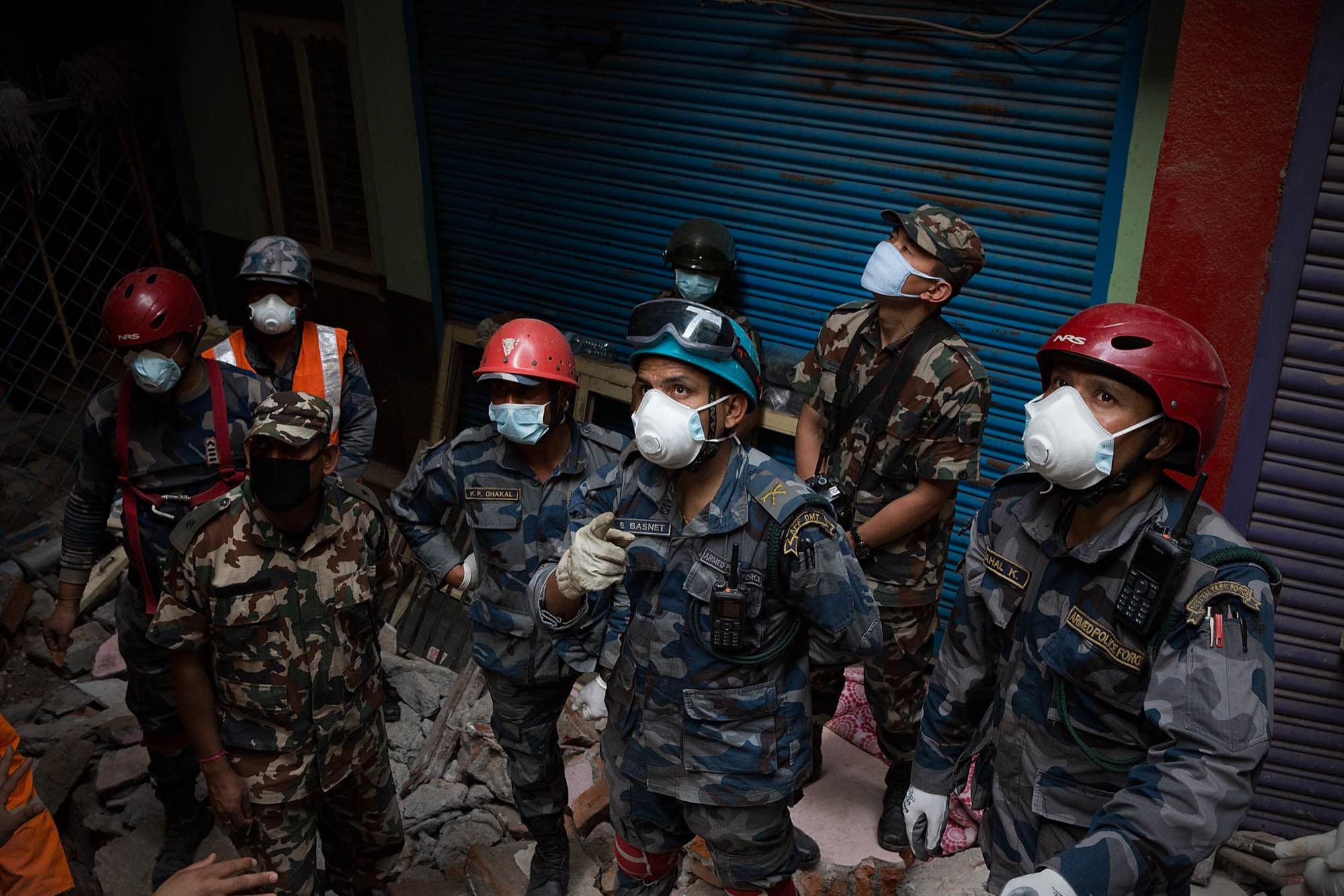 Nepali rescue workers discuss safety concerns as they prepare to remove a body from the wreckage of a building in Kathmandu, Nepal on May 1, 2015.