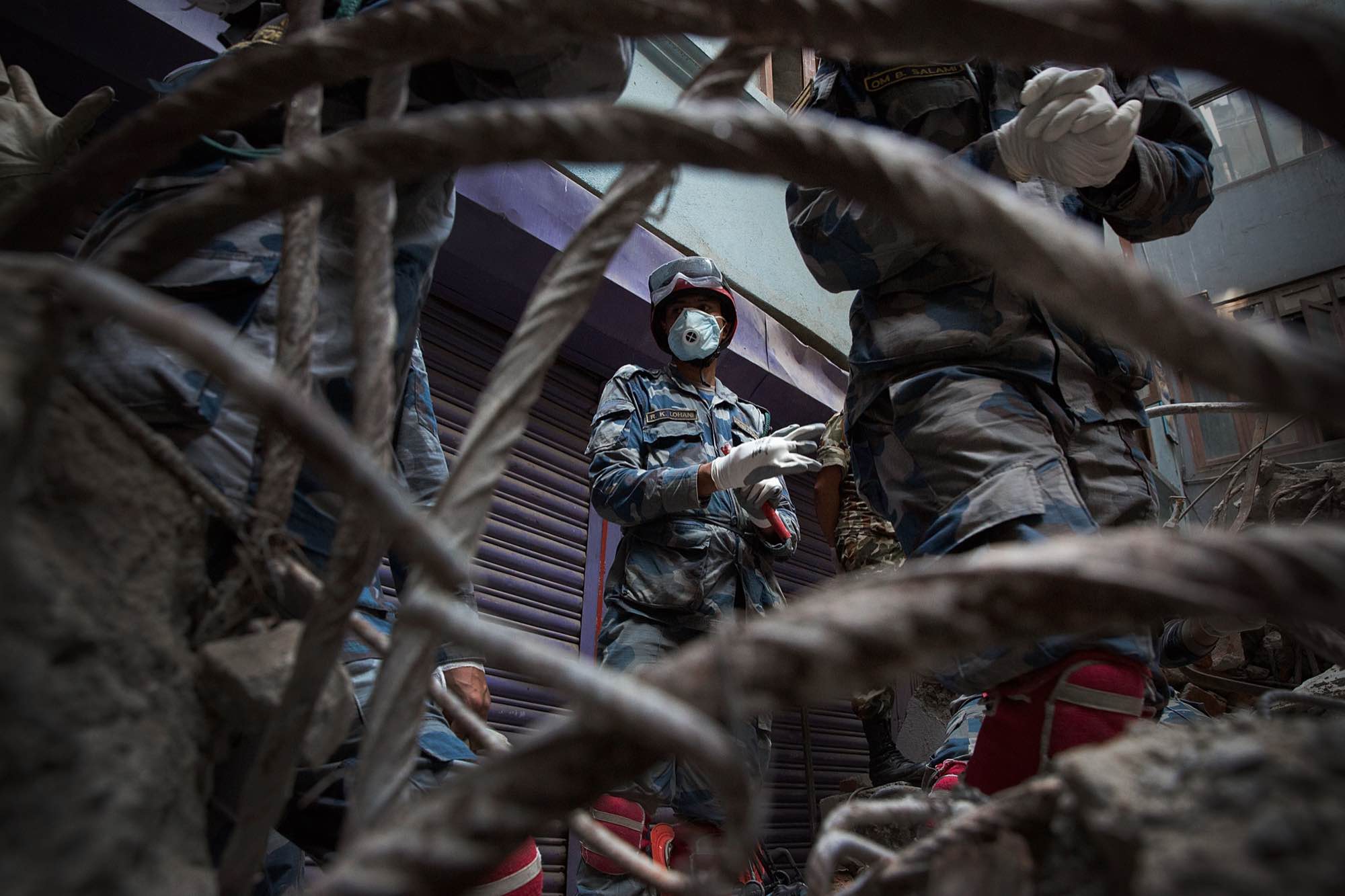 Nepali rescue workers put gloves on after they find a body in the rubble of a collapsed building in Kathmandu, Nepal on May 1, 2015.