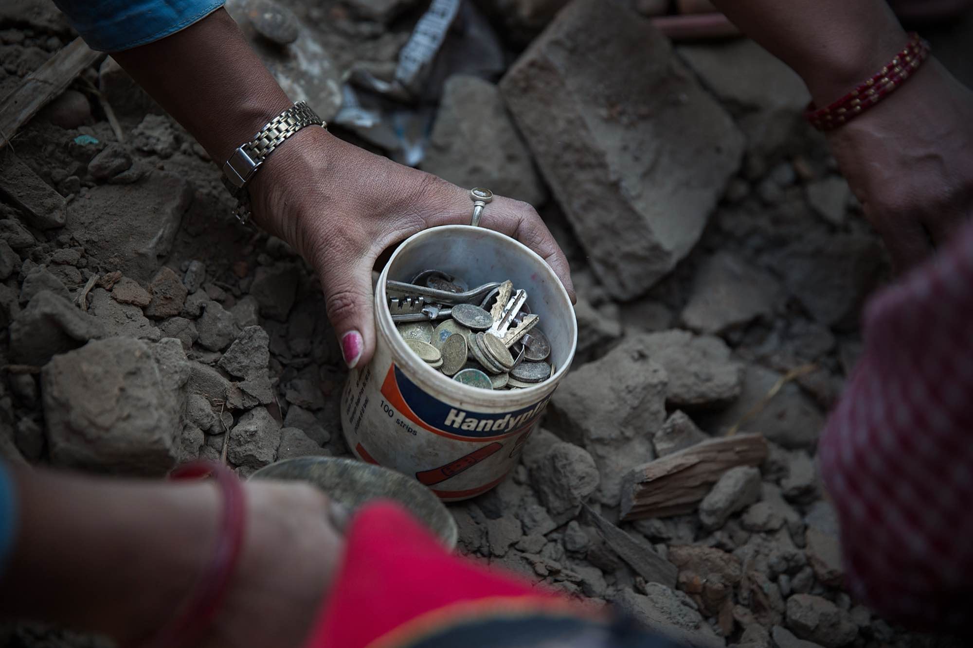 Nepali women comb through the rubble of their devastated home looking for valuables in Bhaktapur, Nepal.