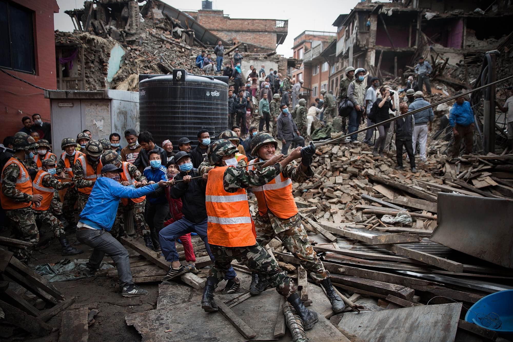 Nepali soldiers and civilians try to pull down a dangerous section of severely damaged wall that is in danger of collapsing in Bhaktapur, Nepal on April 30,…